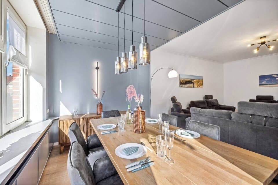 Der helle Essbereich mit stilvoller Beleuchtung bietet Platz für gesellige Runden und geht harmonisch in das gemütliche Wohnzimmer über.