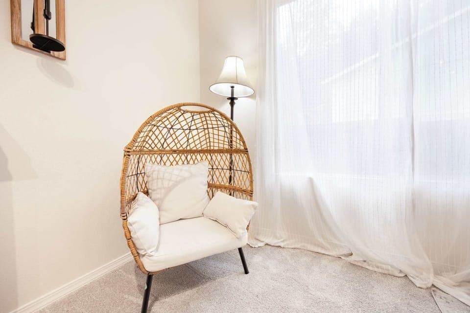Another egg  chair next to the window, enjoying the natural light while reading a book.