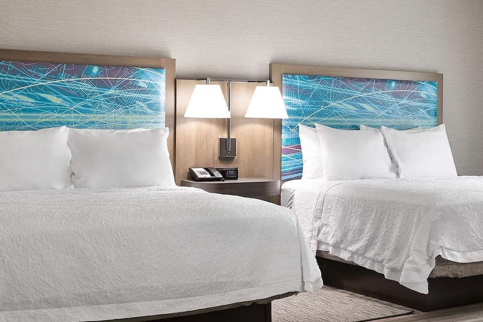 Sink into plush beds under warm, calming bedside light.