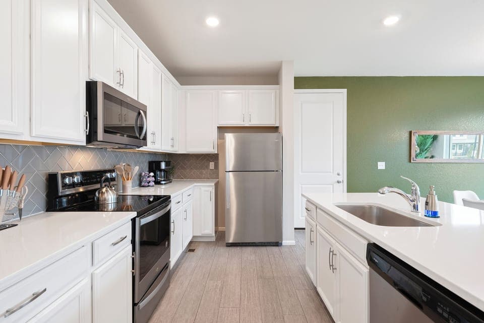 Modern kitchen with stainless appliances, white counters, perfect city retreat.