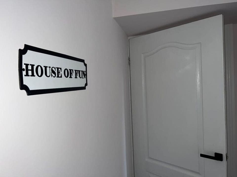 "HOUSE OF FUN" sign by a white door