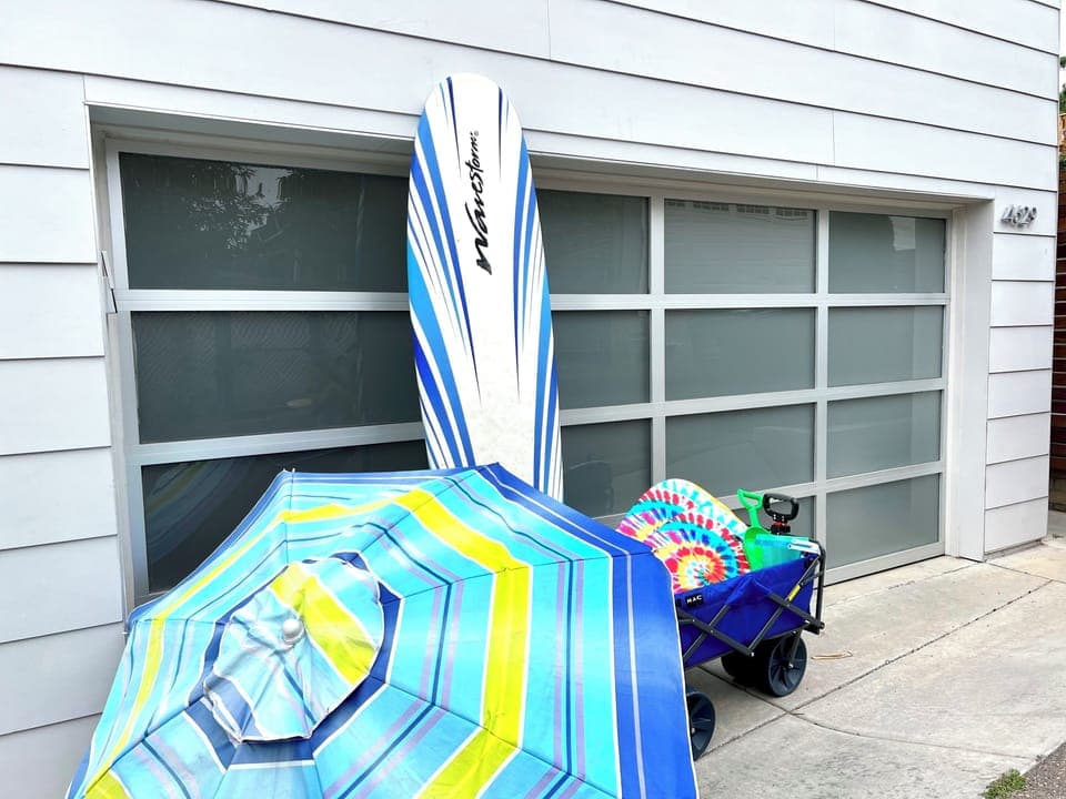 We've got beach gear! Surfboard, umbrella, wagon, 2 boogie boards and sand toys.