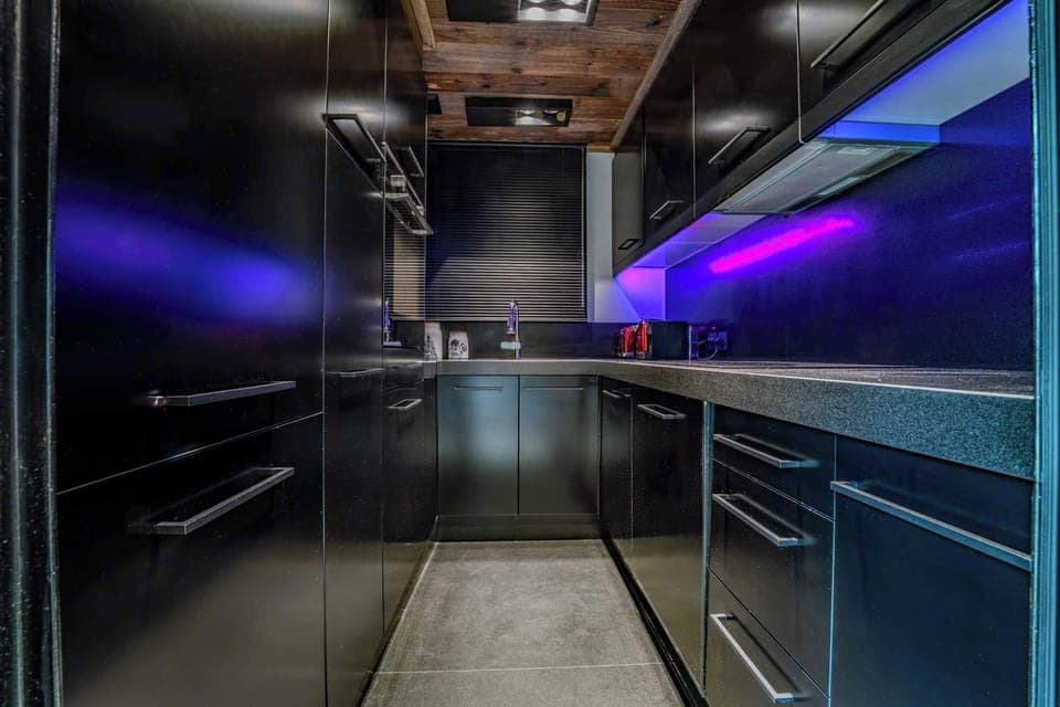 Sleek modern kitchen in your Megève apartment—fully equipped for mountain meals, from hearty breakfasts to fondue nights, with mood lighting and chic alpine finishes.