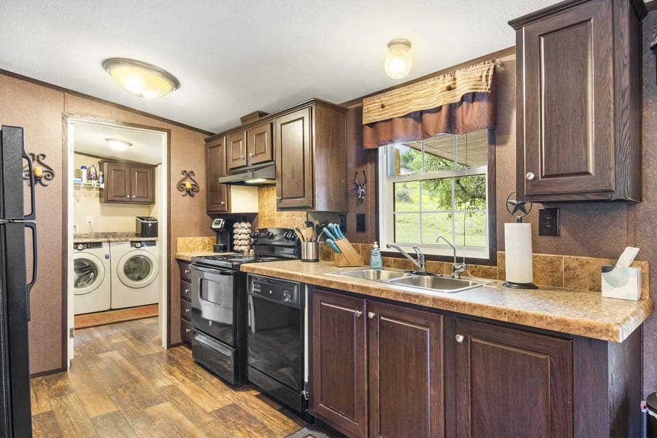 Fully equipped kitchen with modern appliances and a laundry room just steps away-everything you need for a comfortable stay.
