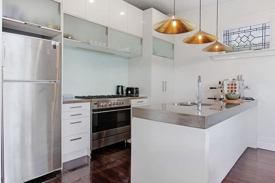 The kitchen is well-equipped with a coffee machine, dishwasher, microwave, gas cooktop, oven, and fridge/freezer.