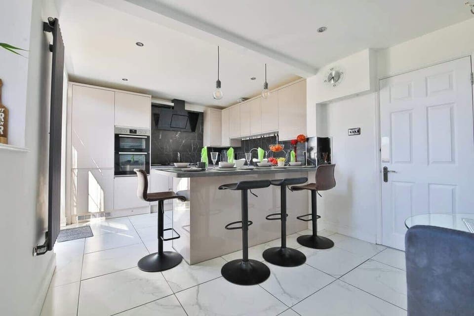 A modern, fully fitted kitchen with breakfast bar—great for preparing meals or sharing a drink.