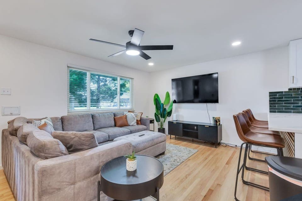 Living room with plush couch, TV, ceiling fan