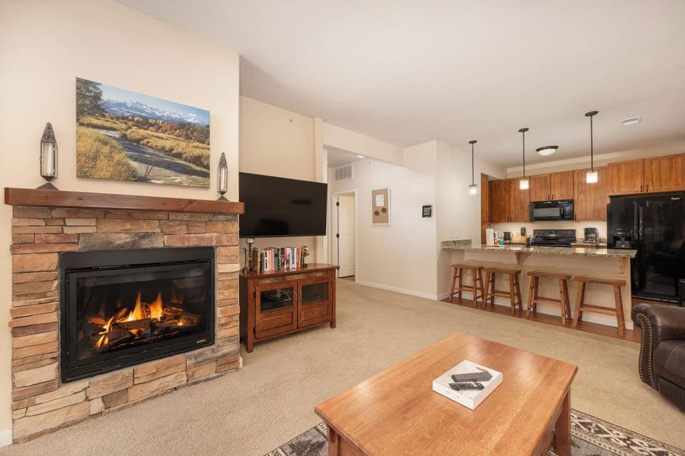 Cozy up by your crackling fireplace at Ten Mile G-201 while enjoying the open kitchen and warm wood accents that make this space feel like home.