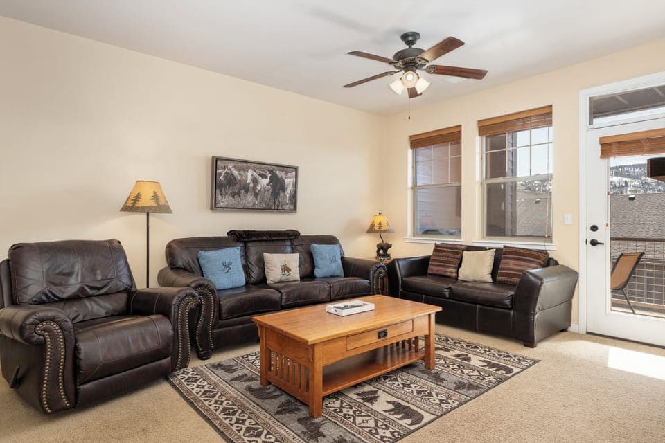 Sink into plush leather sofas in your spacious living room at Ten Mile G-201, where a gentle ceiling fan keeps you cool and natural light streams through large windows.