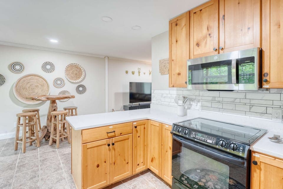 Cook up vacation feasts in this fully equipped kitchen with warm wooden cabinets and modern appliances.