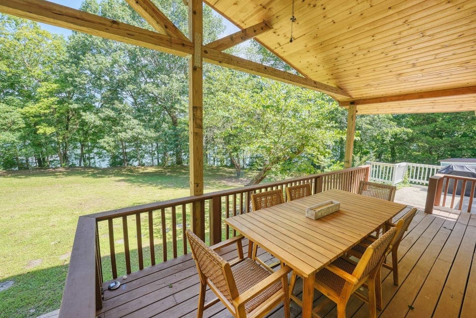 Inviting covered deck with a spacious dining area overlooking a peaceful, tree-lined backyard.