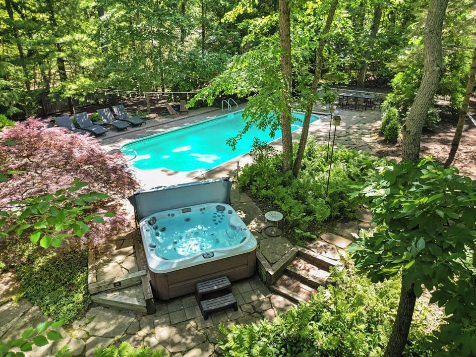 Lounge poolside surrounded by trees and sunshine.