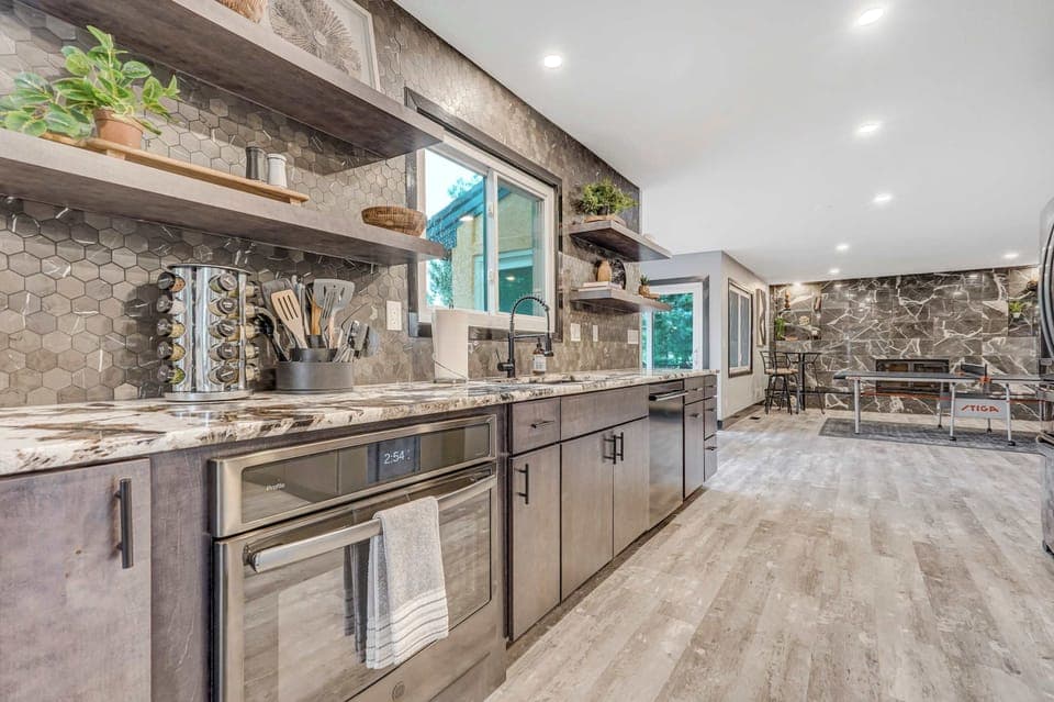 Stylish and fully stocked kitchen with granite counters, open shelving, and everything you need for home-cooked meals.