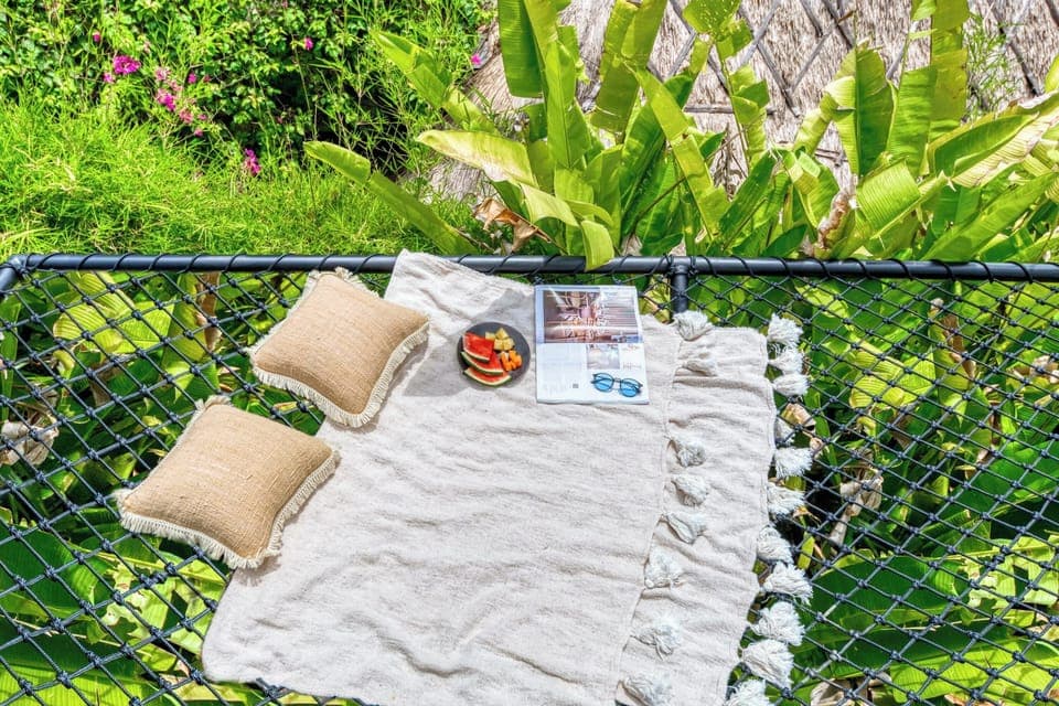 Lush greenery surrounds you as you relax on the net bed