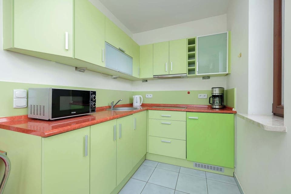 Fully equipped kitchenette with electric cooktop, oven, electric kettle, coffee maker, toaster, refrigerator with freezer and washing machine.