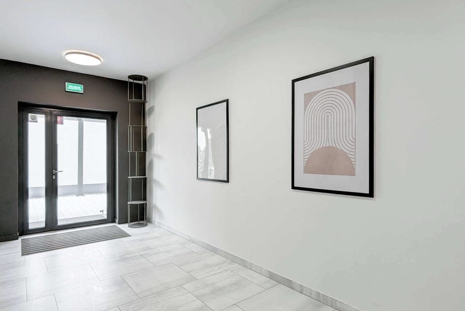  Building entrance hall with a clean, white interior and modern artwork on the walls. Bright and inviting.