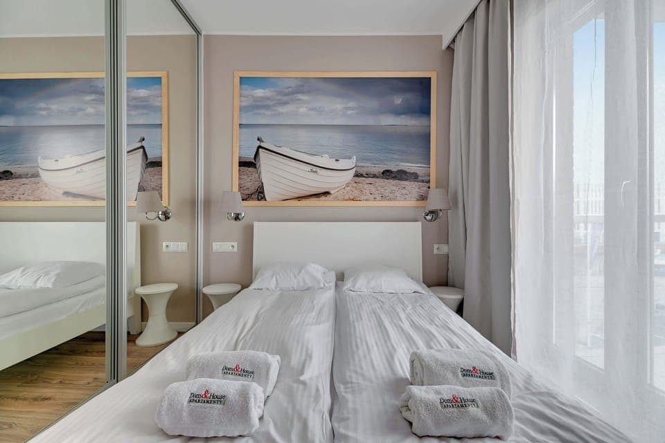 A cozy and harmonious bedroom decorated in light, neutral colors promotes relaxation and tranquility. A large, comfortable bed with white bedding invites rest.