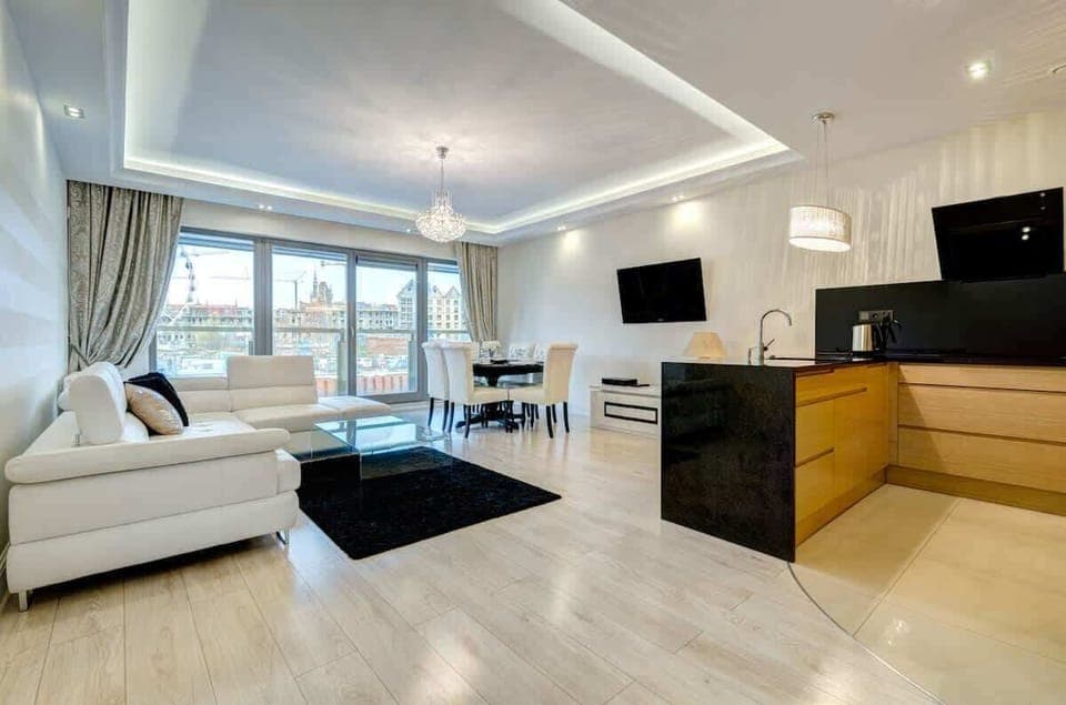 Spacious, open living area with stylish white sofa and modern black accents.