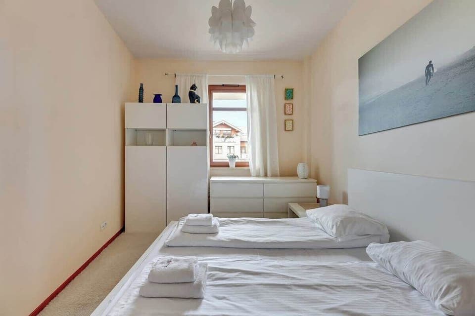 A closer view of the same bedroom, showing additional details of the bed and the painting.