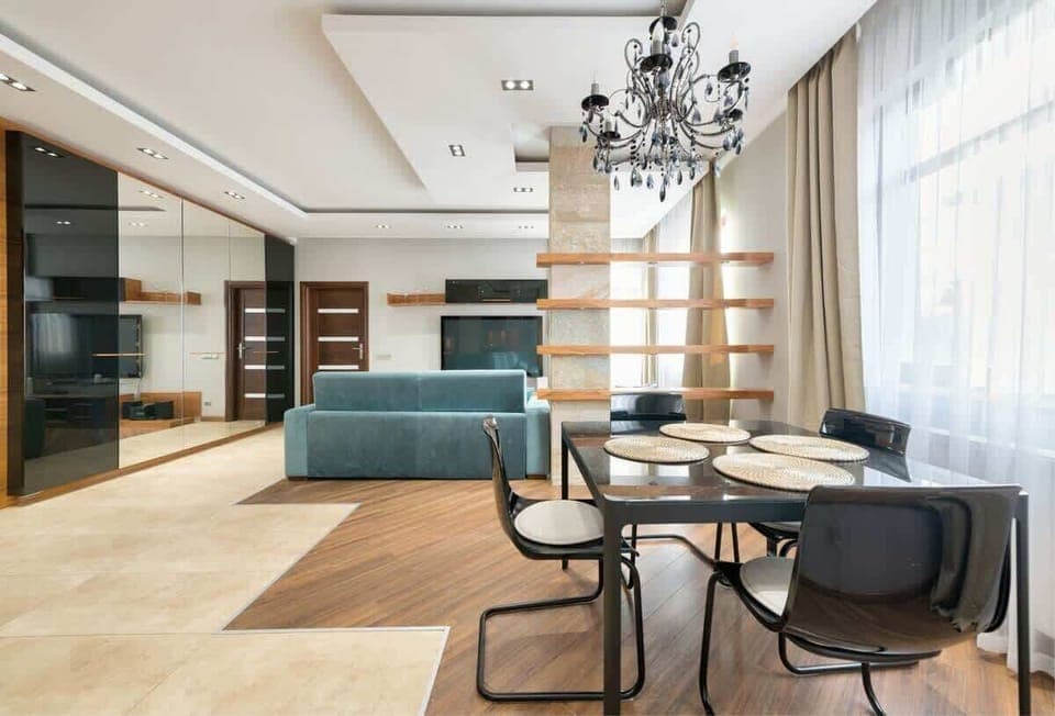 A well-lit dining space that connects seamlessly to a modern kitchen, complete with elegant furnishings.