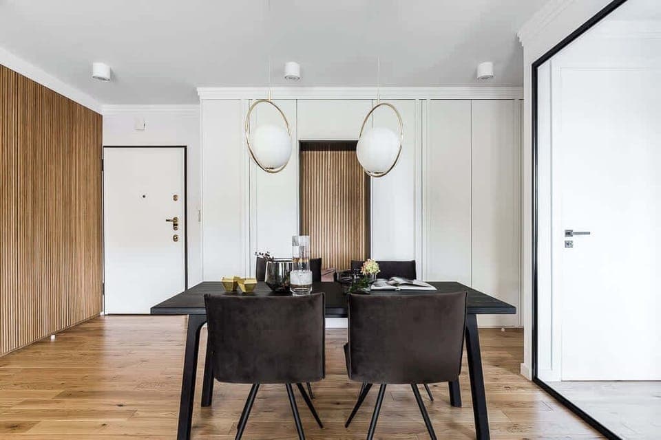 A close-up view of the dining area with wooden panels along the wall, matching the light wood floors and the elegant dining table setup.