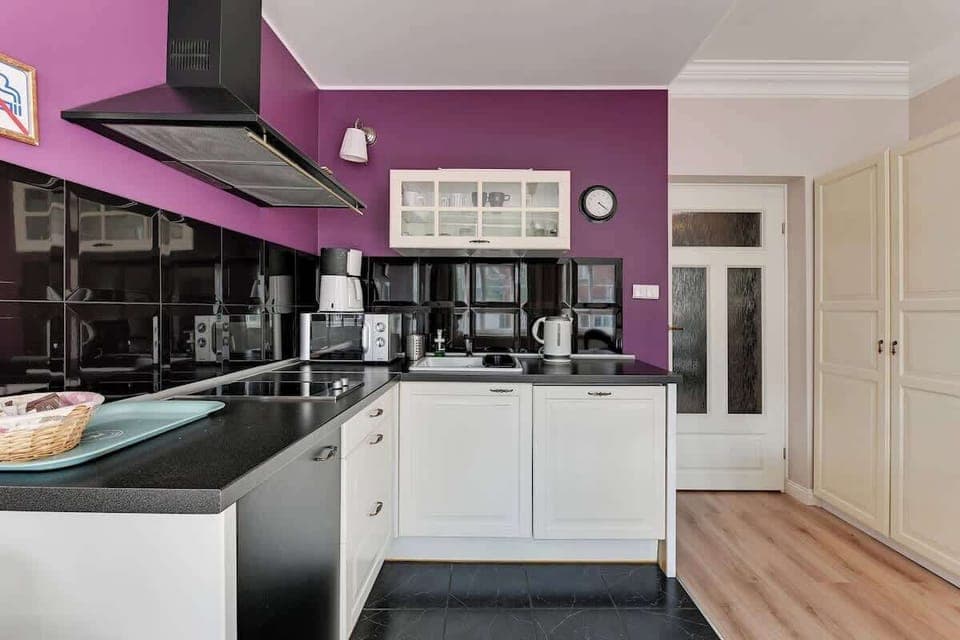 A kitchenette that emphasizes its style with strong color. It is equipped with a microwave oven, electric hob, dishwasher and kettle. 