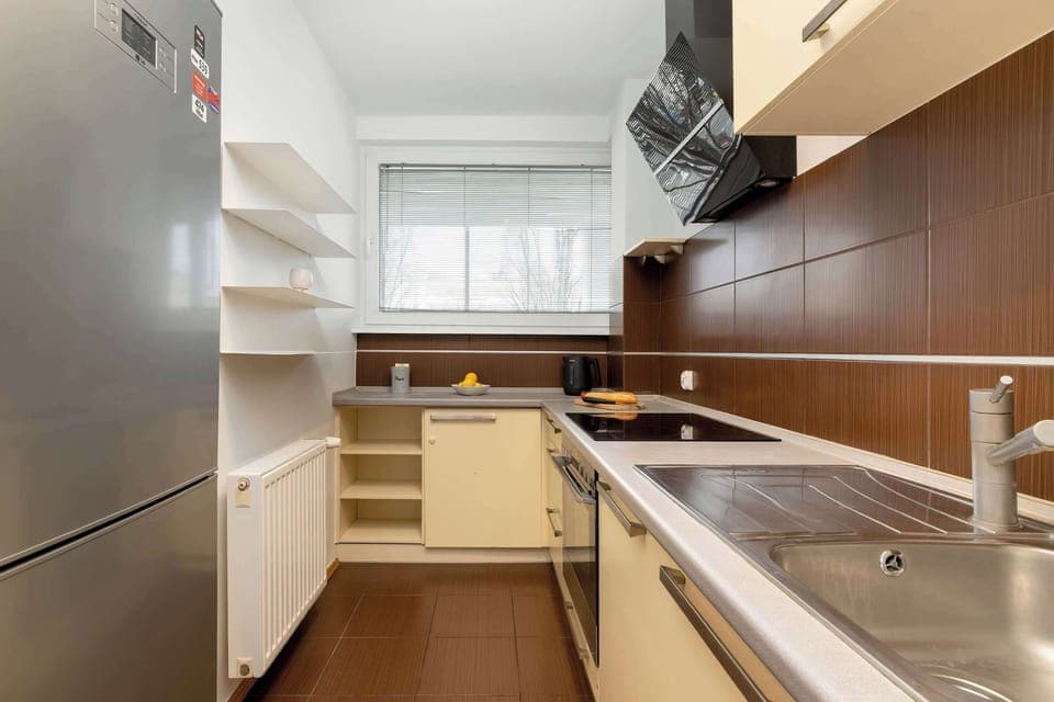A kitchen with wooden cabinets, stainless steel appliances, and a well-organized cooking space.