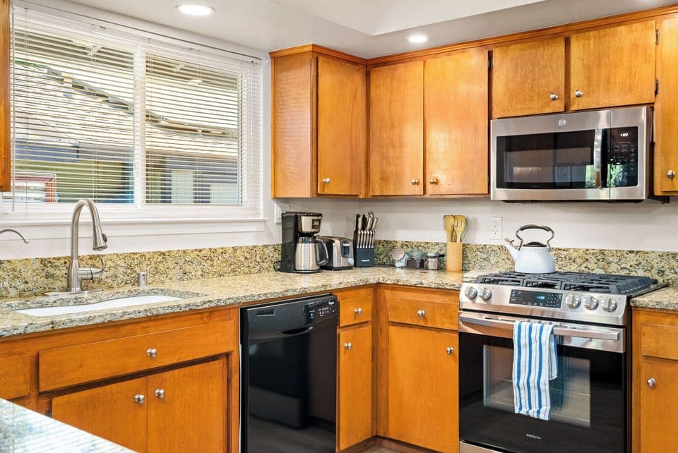 Prepare meals in this fully stocked, highly functional kitchen. It has modern stainless steel appliances, granite countertops, and warm wood cabinetry. Enjoy a convenient cooking experience with a gas range, dishwasher, coffee maker, and full utensil set.