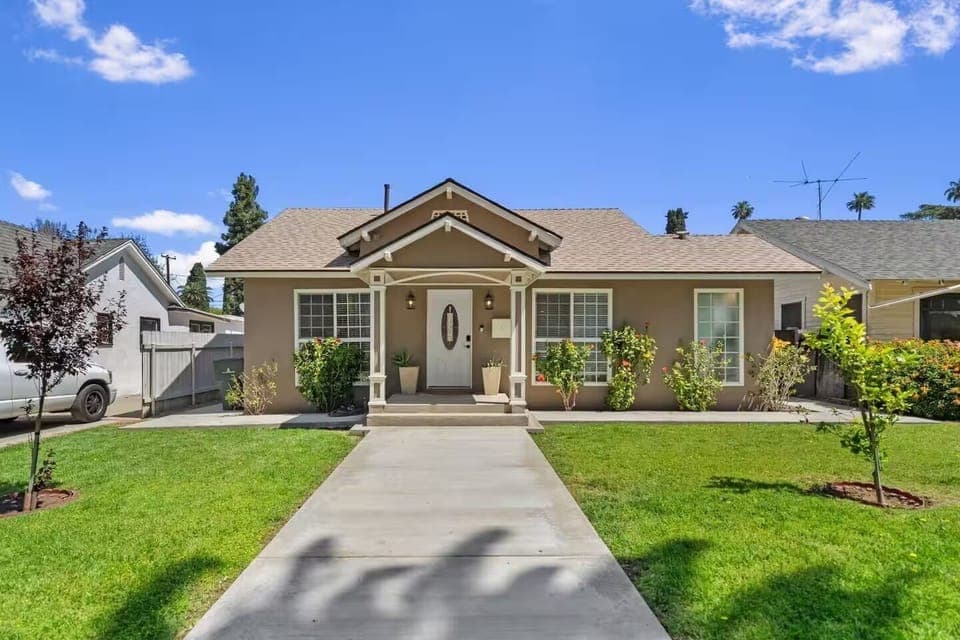 Welcoming front view with porch, fresh lawn, and sunny curb appeal all around.