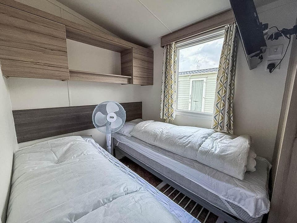 Cozy twin bedroom with natural light and modern storage