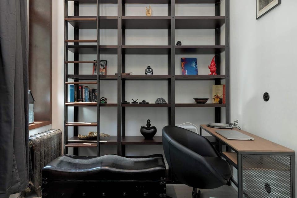 A modern office or library area with black shelving and a desk. Ideal for working or studying from home.