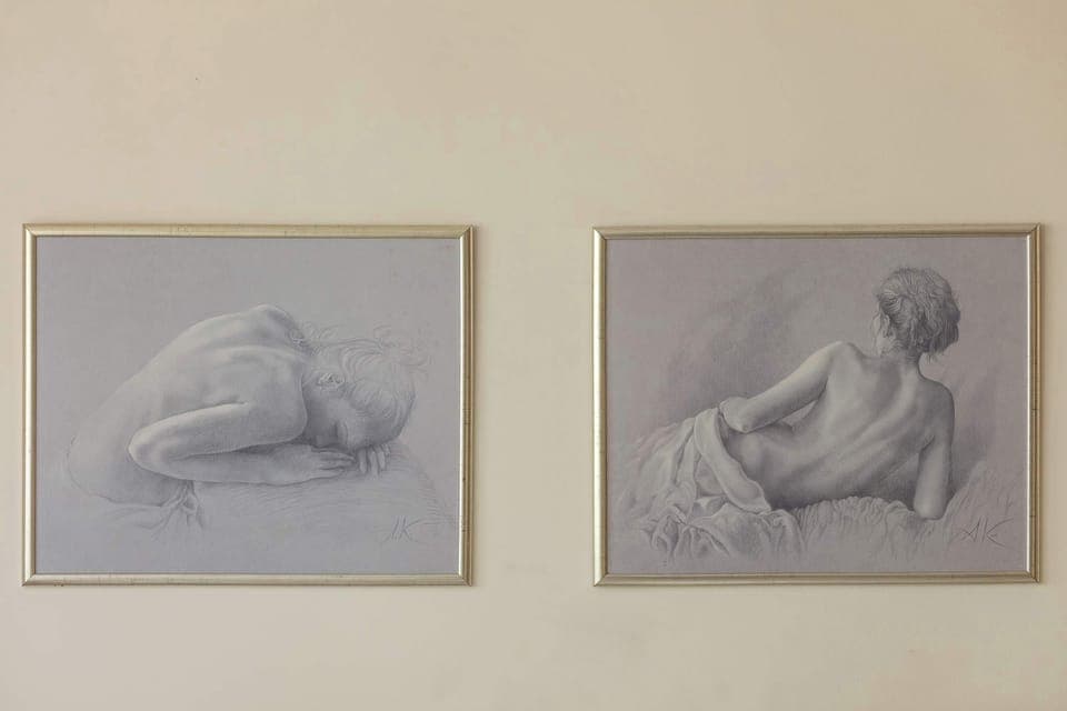 A close-up of decorative paintings in gold frames that give the room a cozy feel.