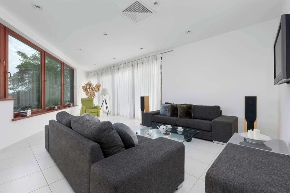 Spacious and bright living area with comfortable seating and modern decor.

