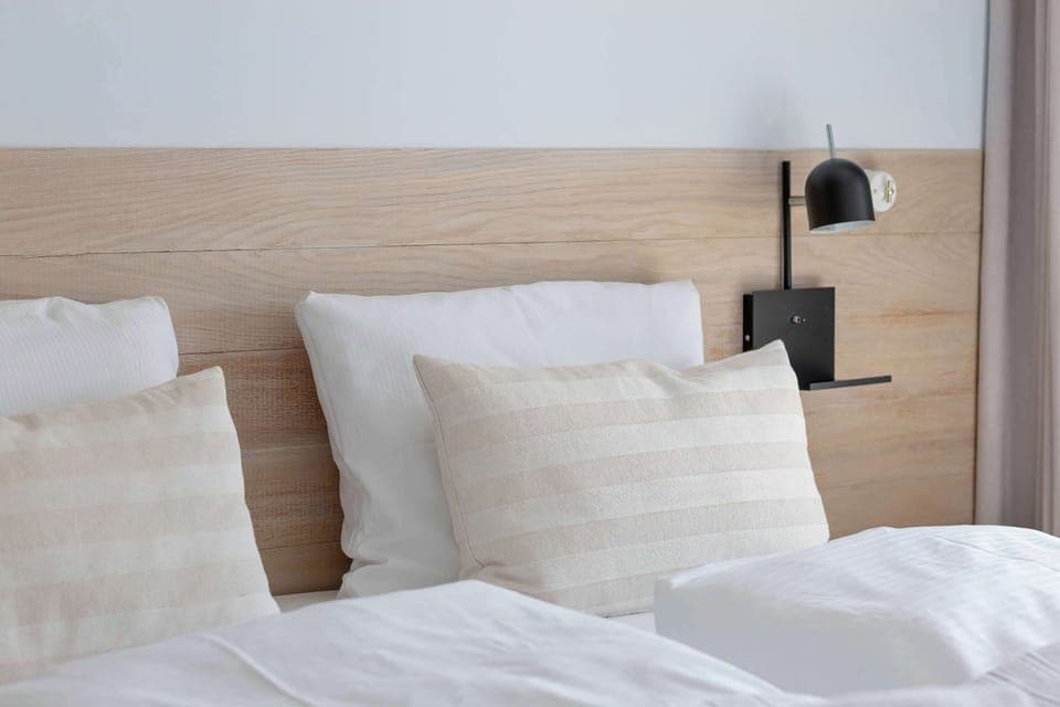 Close-up of a cozy bed, highlighting pillows and headboard details.