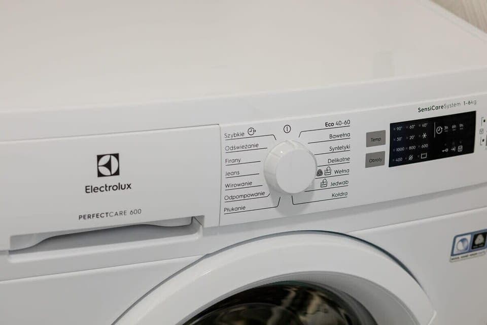 Washing machine close-up showing control panel and drum.