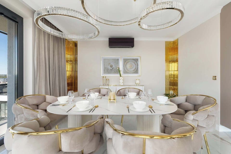 An elegant dining room with a large table and designer chairs is located in the open living area, creating an ideal place for communal meals.