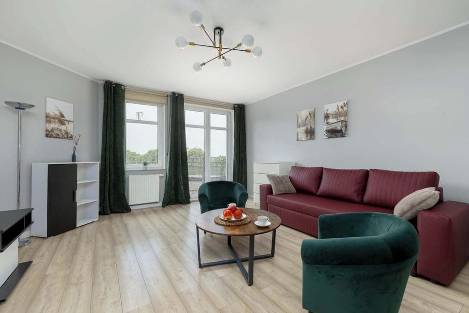 Spacious living room with a fold-out sofa bed, two armchairs, coffee table and TV.