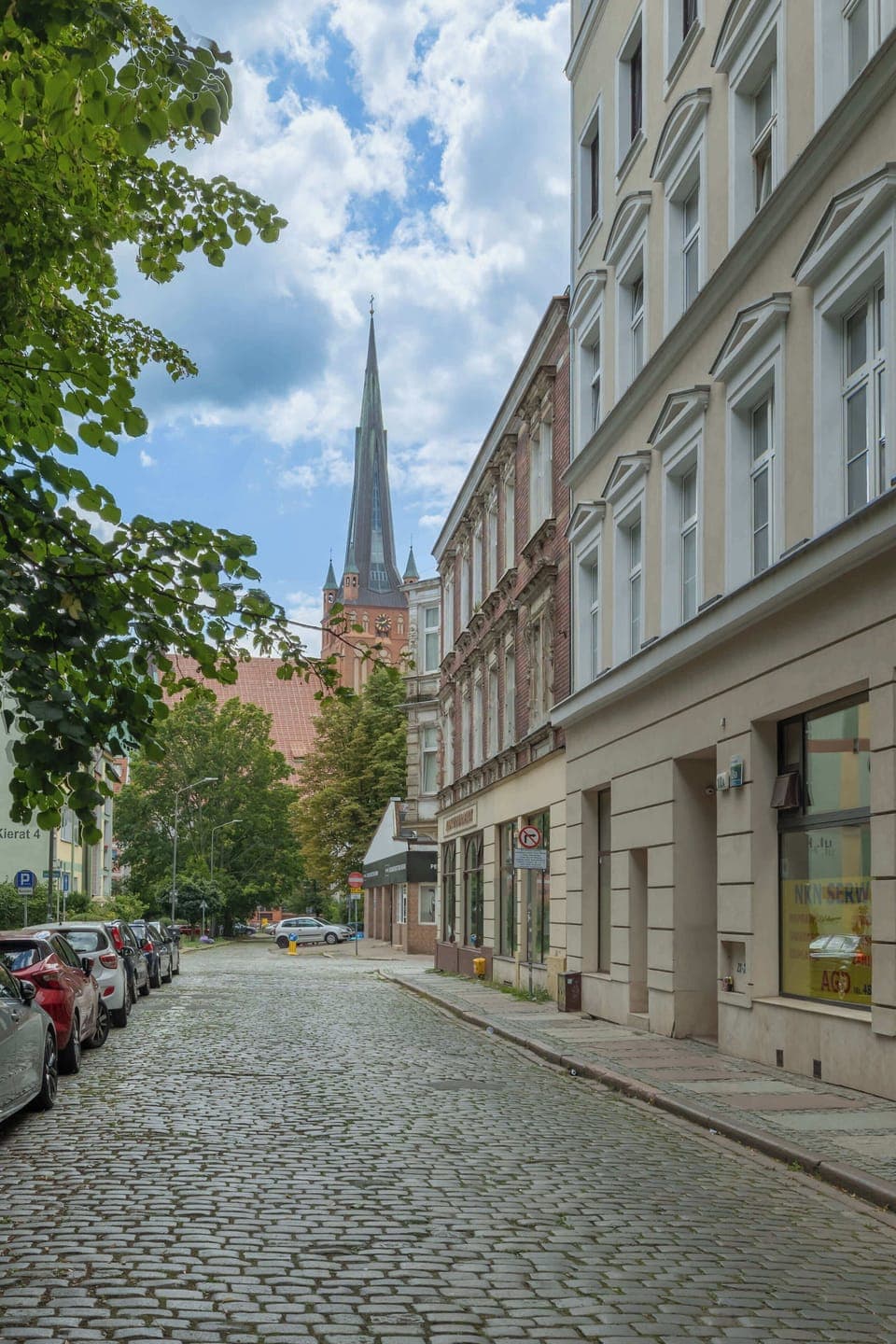 A close-up of the building’s main entrance, highlighting the polished stonework and well-maintained surroundings. The entrance feels modern and inviting.