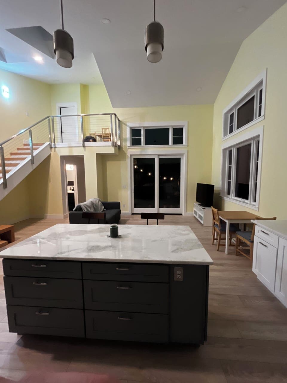 Kitchen island and living room with glass door out onto private deck. 