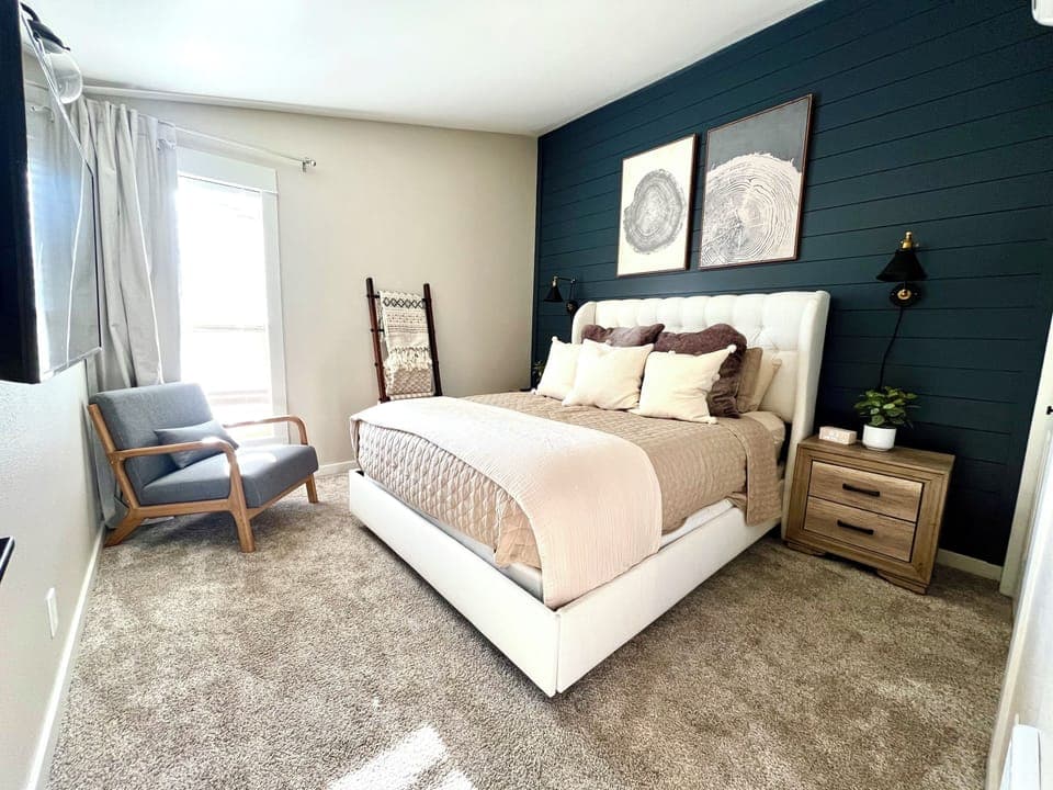Unwind in a plush queen bed with cozy textures.