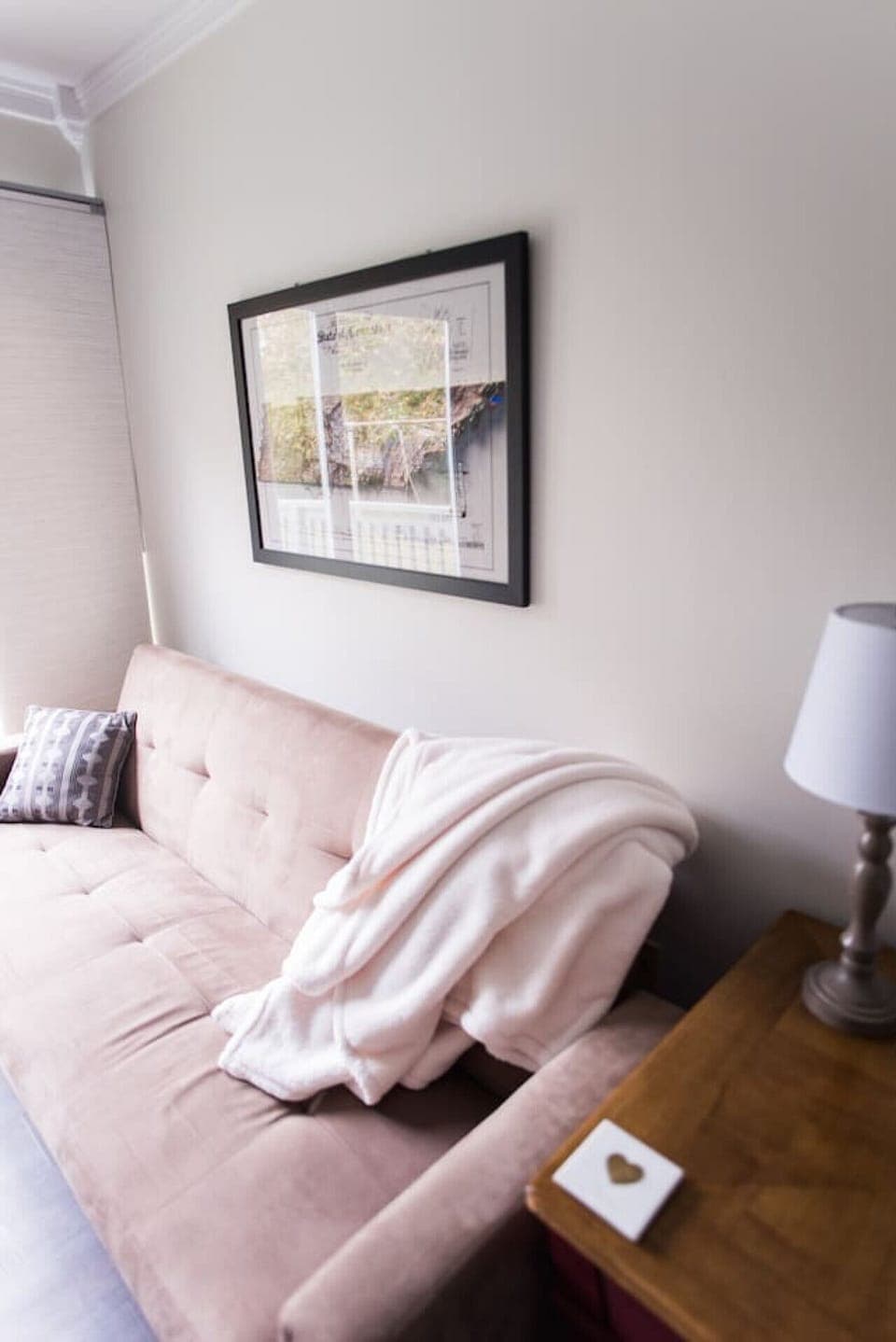 Living room with TV, Bose surround speaker, twin pull out bed, and natural lighting.