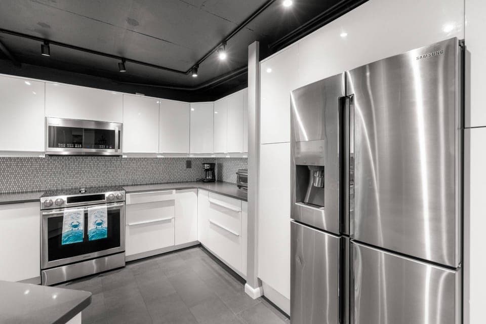 Updated, Fully Equipped Kitchen with Sleek White Cabinets and Stainless-Steel Appliances