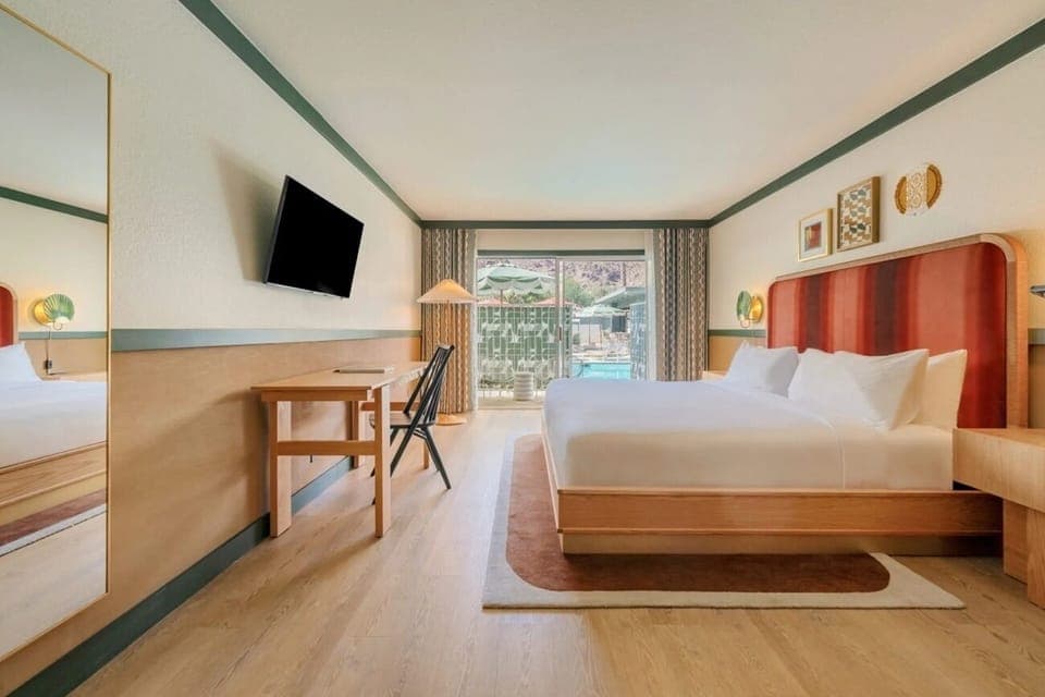 Unwind in a sunlit room with balcony views and plush bed.