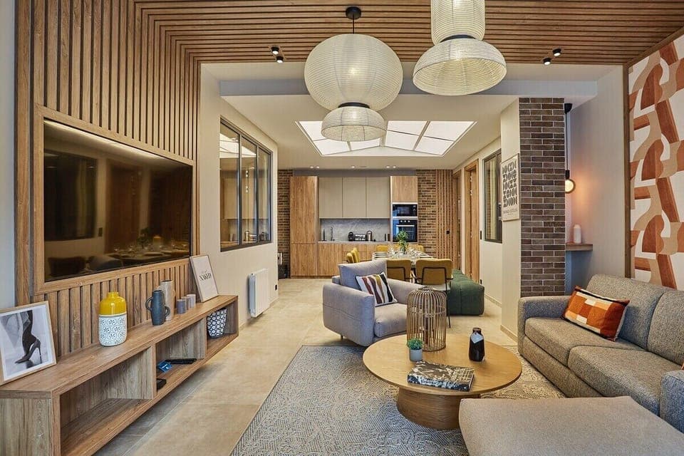 Salon avec canapé lit, télévision, wifi, cuisine américaine et grande table pour 10 personnes