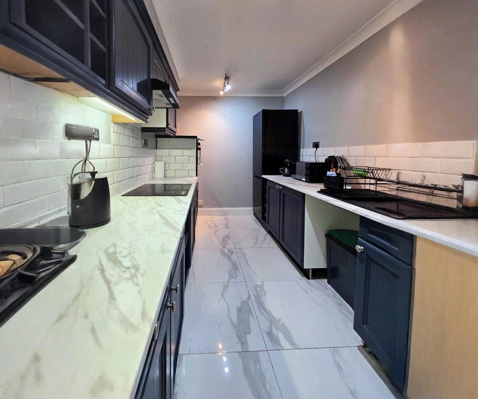 Kitchen with washing mobile, fridge freezer and microwave.