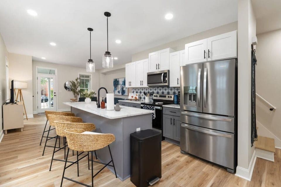 Modern kitchen with granite counters, stainless appliances, and large island seating.
