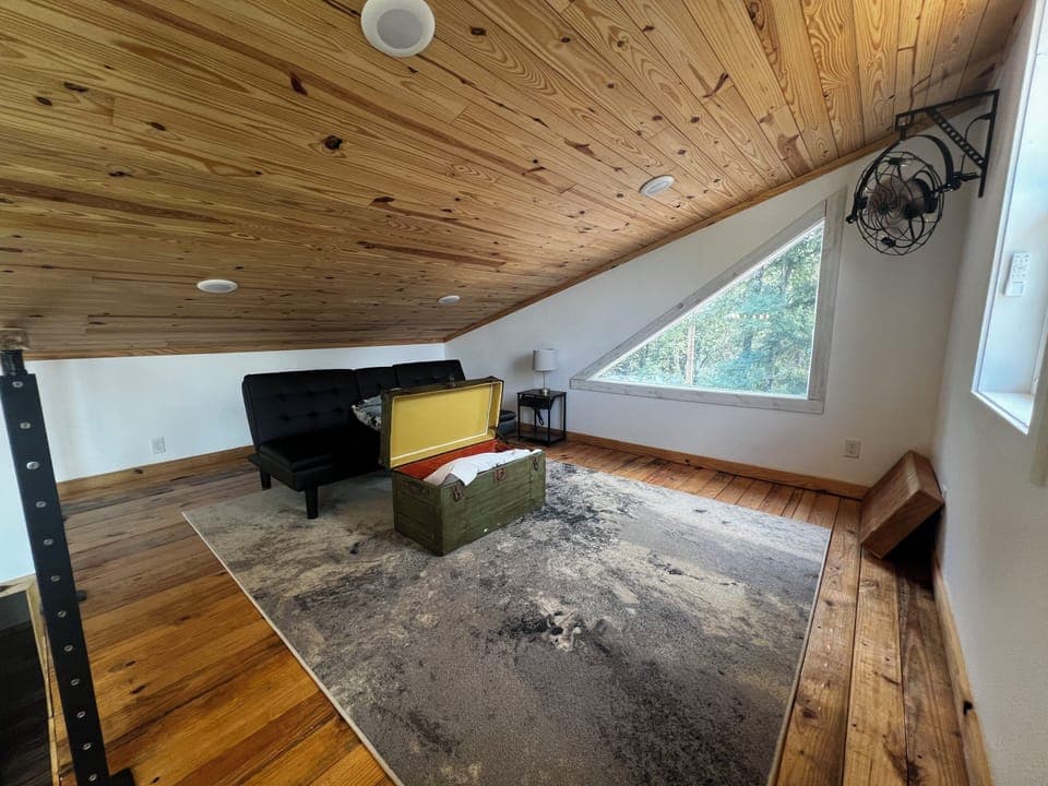 Loft area with a repurposed military trunk for storage