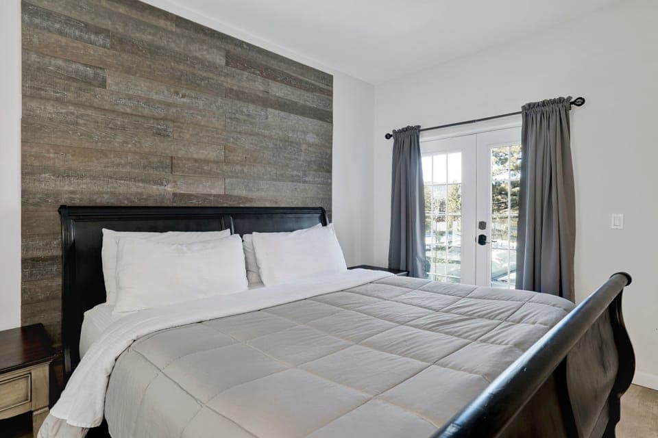 Peaceful cabin bedroom with plush bedding, and beautiful views—ideal for restful nights, cozy mornings, and a relaxing mountain escape.