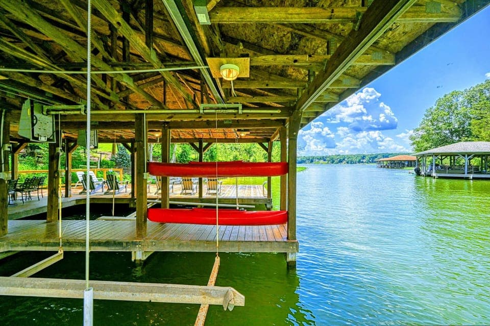 Dock - Red kayak and canoe stored in the covered dock with open views to the lake beyond.