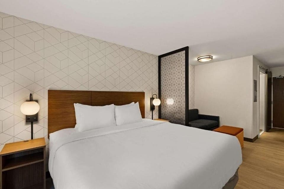 Unwind in crisp linens with warm, modern bedside lighting.